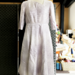 『着物からオーダーワンピース』<br>
こちらは、お客様が持ち込まれた着物をワンピースに仕立て上げた1着です。<br>
ちょっとしたオシャレなポイントとして、首周りが斜めのVの字に仕上げているという事でしょうか。これは、お客様のご要望として取り入れました。<br>
「ただのVの字では面白くない。」との事でしたので、この様な形にしました。<br>
着物の高級感を感じれる様に、シルエットはシンプルですが、<br>
その為、合わせるアウターも選びやすいのではないでしょうか。<br>
お時間は約1ヶ月頂きました。裏地とコンシールファスナーは当店で用意しましたので、お値段は¥45,600(税込)となりました。<br>
タンスに眠っている、着る機会が無い着物をお持ちの方は、<br>
ご参考になさってください。